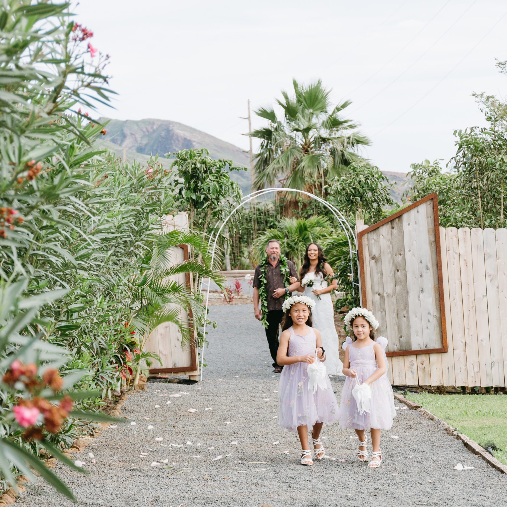 two flower girls walking down a path