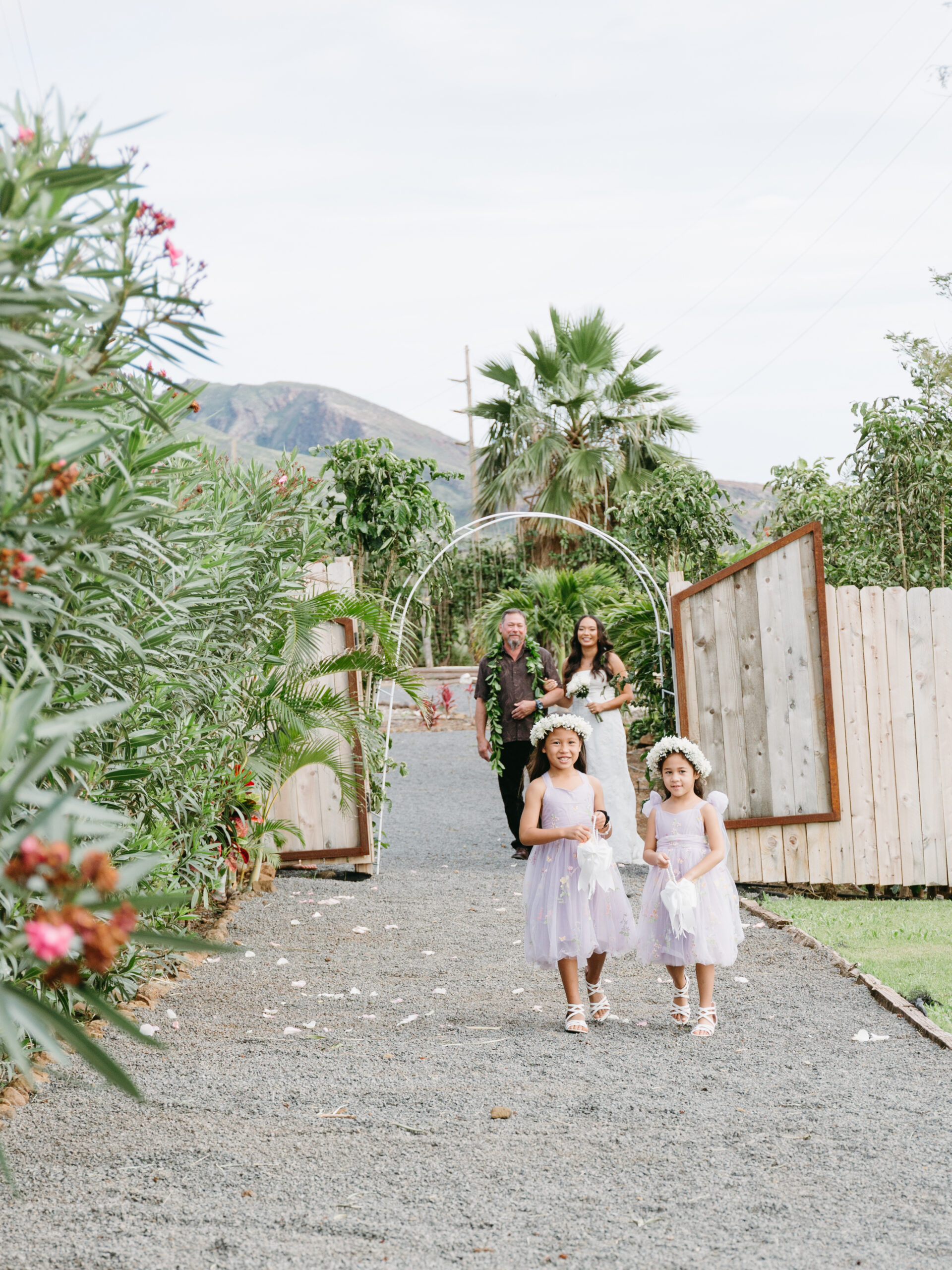 two flower girls walking down a path