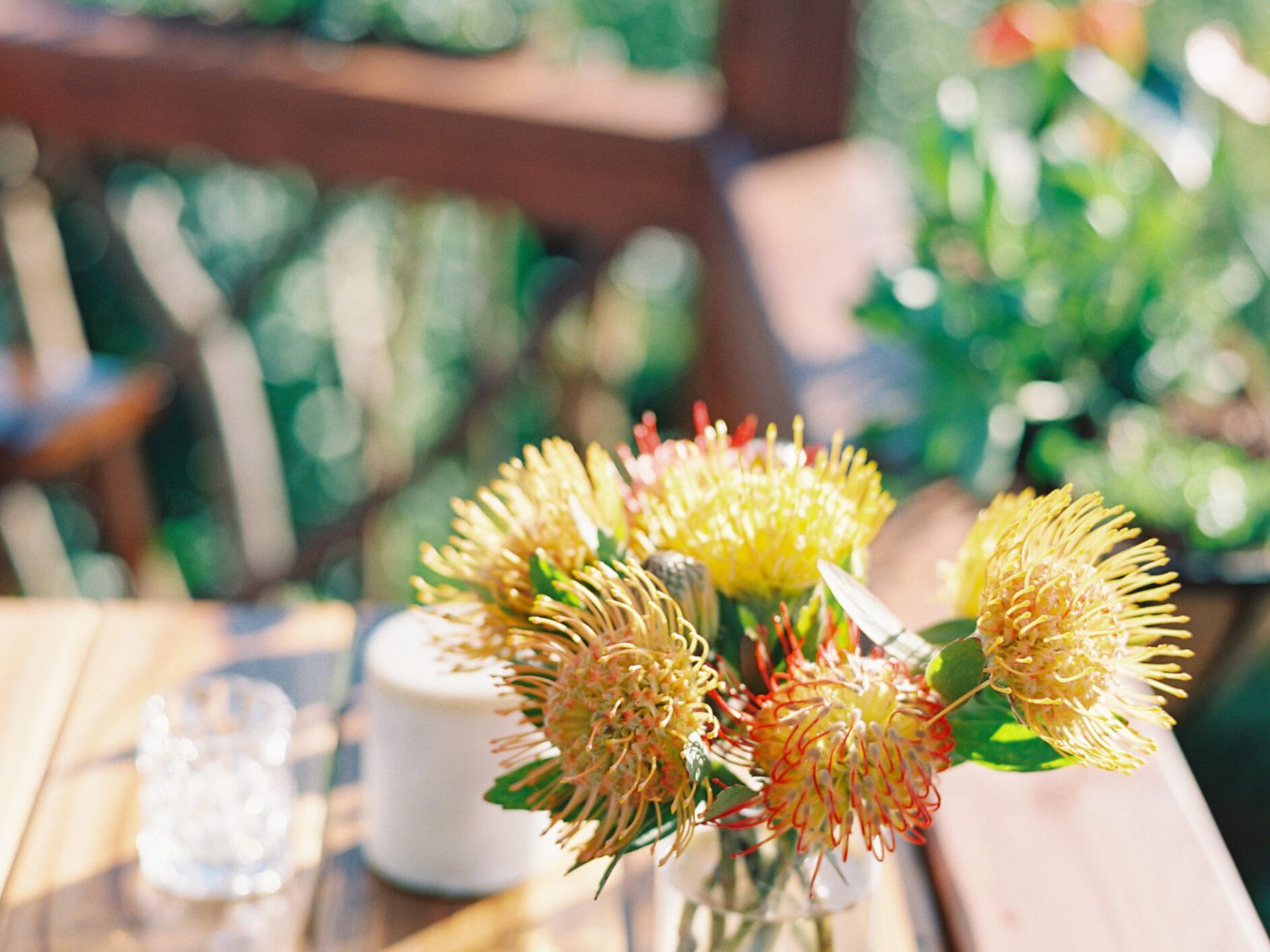 a vase of flowers sitting on top of a wooden table