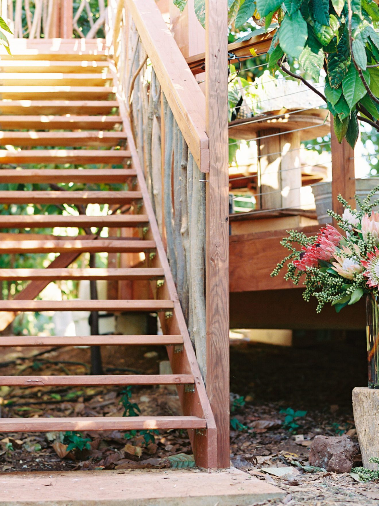 a vase of flowers sitting on top of a wooden fence