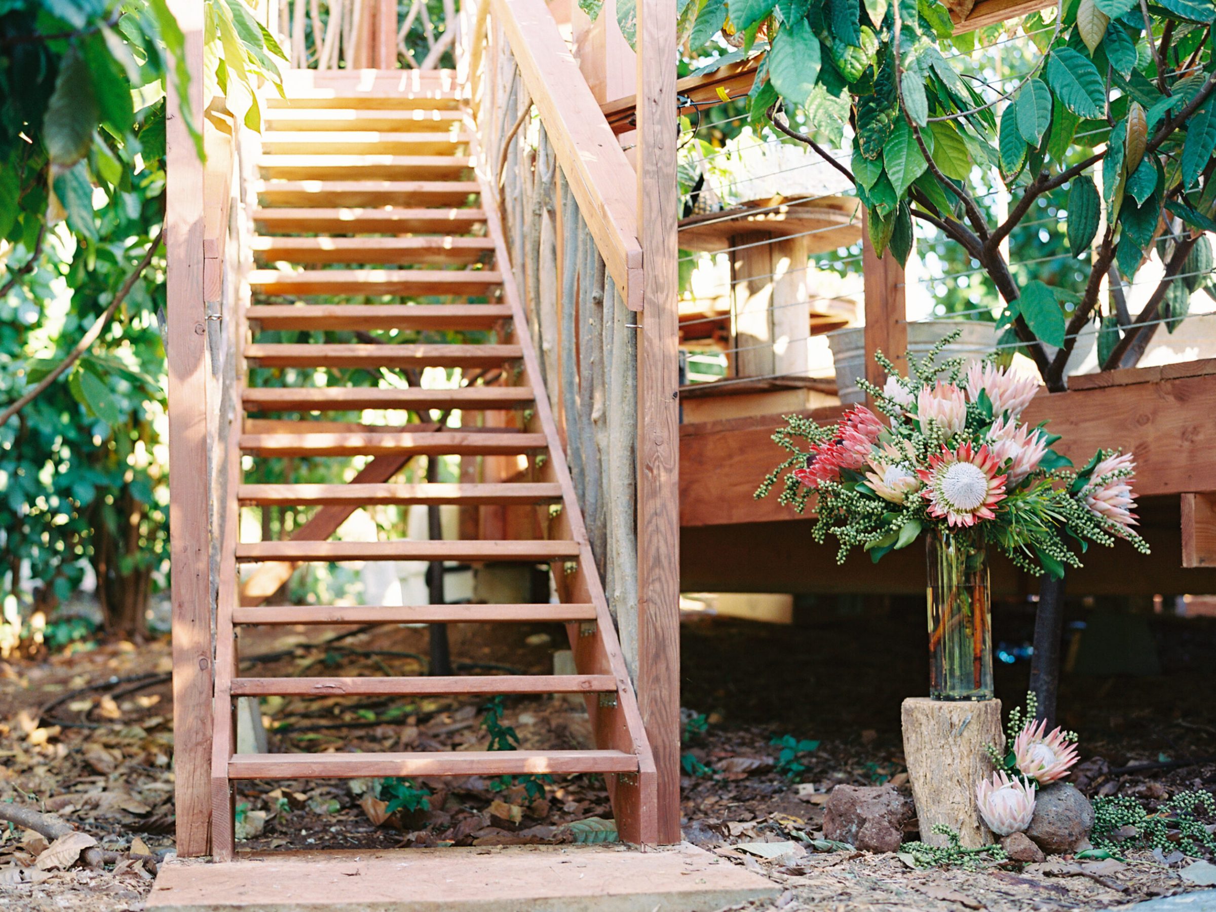 a vase of flowers sitting on top of a wooden fence