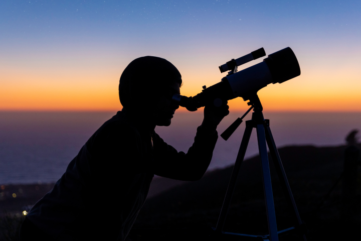 a man standing in front of a sunset